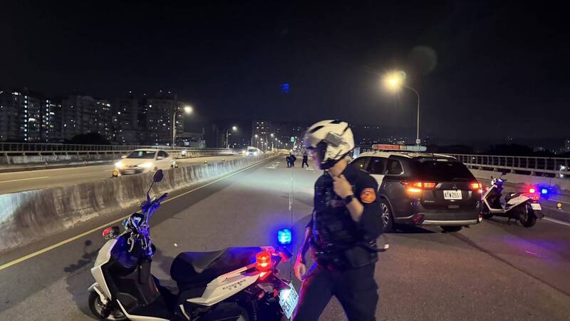 新北市一辆运钞车在板桥浮洲桥上掉落一袋零钱，警方警示封路。（记者吴仁捷翻摄）