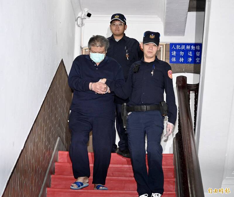 退役中校谭俊明在法警戒护下进入法院应讯。（记者罗沛德摄）