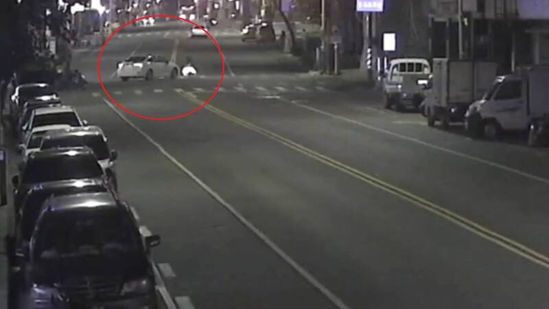 行人走在斑馬線上，白色轎車左轉行駛而來。（民眾提供）