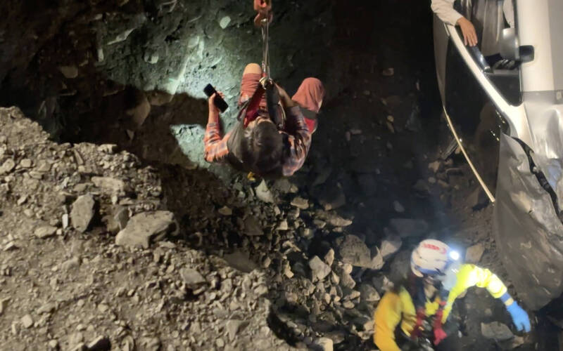 救难人员将2人吊挂至路面。（民众提供）