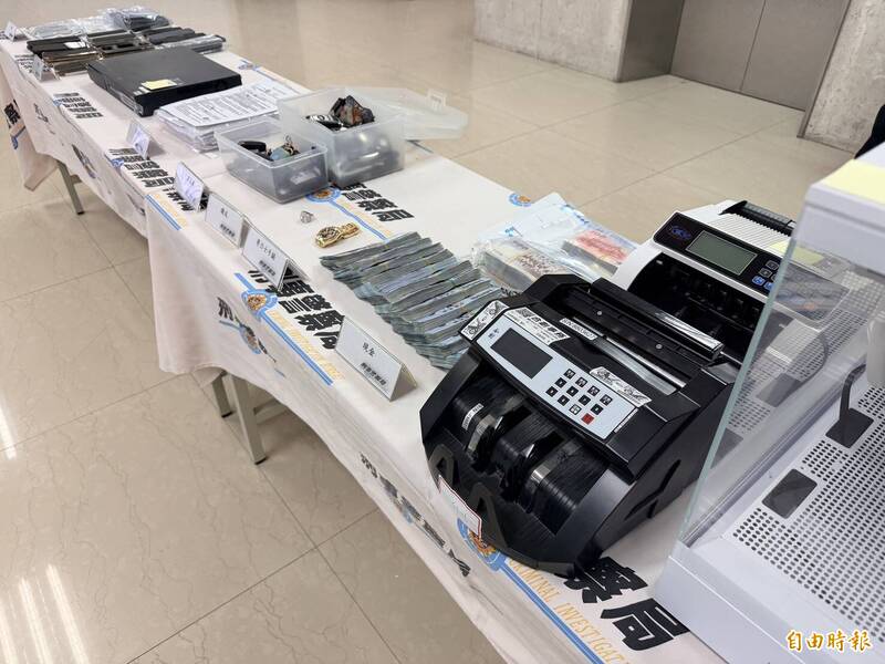 警方查扣現金180萬多元與手機、存摺本、自然人憑證、K盤、球棒、帳冊本、隨身碟、汽車鑰匙、鑽戒、勞力士手錶及相關貸款文件等證物。（記者邱俊福攝）