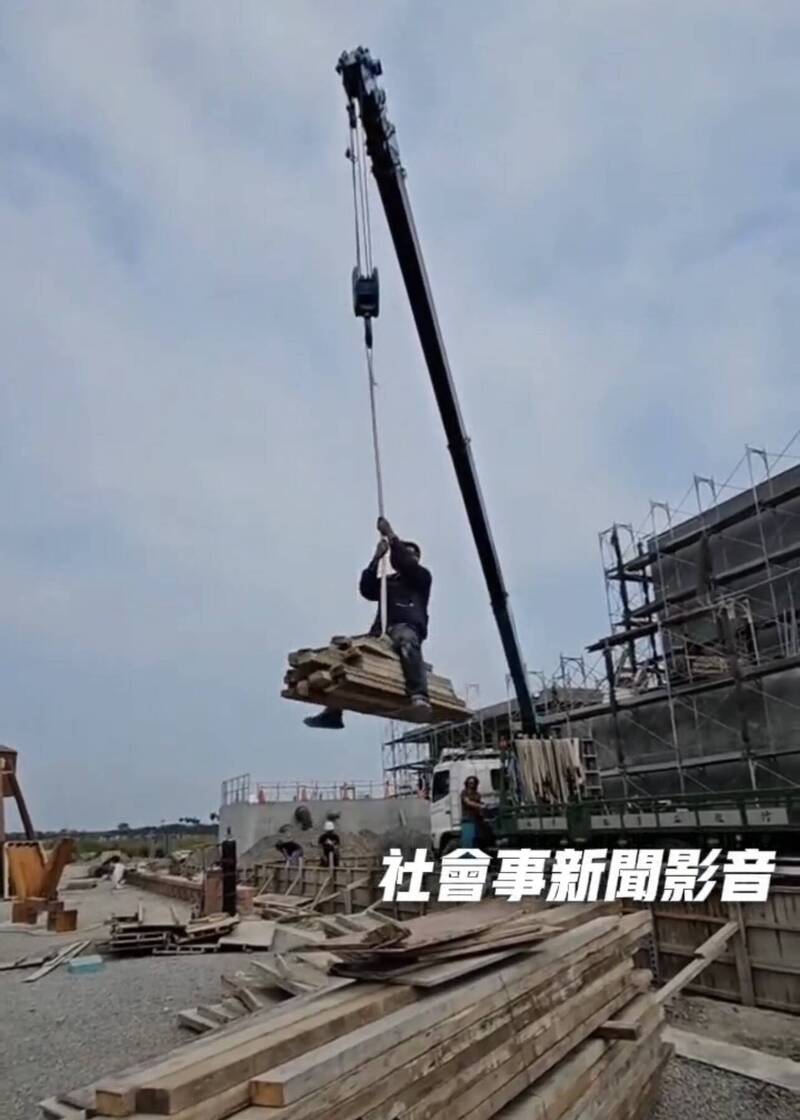 工人坐在模板上随吊车垂降到地面，过程中还如牛仔驯马般前后摇晃嬉戏。（取自「社会事新闻影音」）