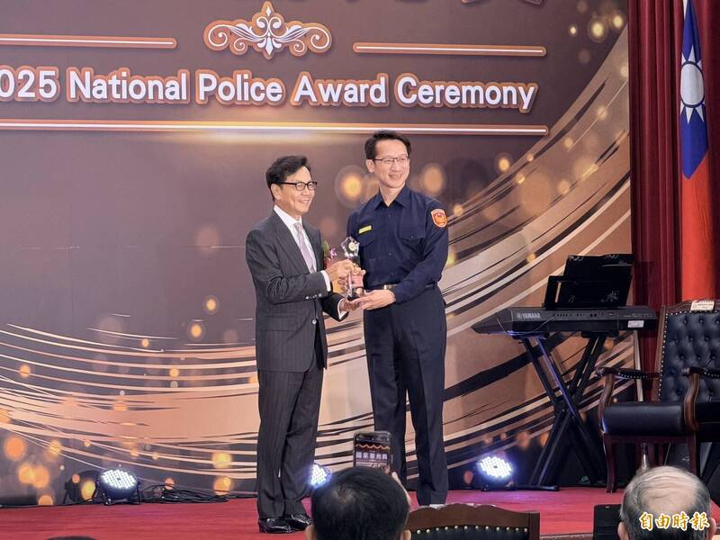 警政署今天举办年度「114年国家警光奖颁奖典礼」，中华民国警察之友总会理事长蔡明忠颁奖给团体组获奖的屏东县警局，由局长甘炎民领奖。（记者邱俊福摄）