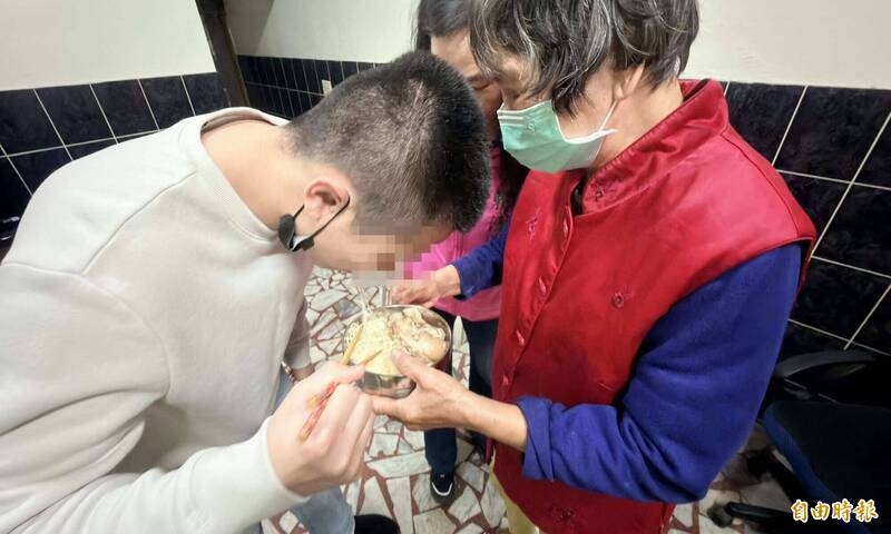 黃男品嘗阿嬤為他準備的豬腳麵線。（記者湯世名攝）