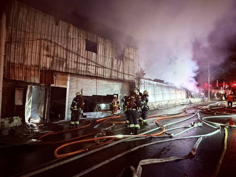 新北市八里一間木作鐵皮工廠今天凌晨失火，火勢大作，延燒燒毀三間工廠，起火原因仍待調查，新北市針對鄰近雙北四區發出空汙警戒。（記者吳仁捷翻攝）