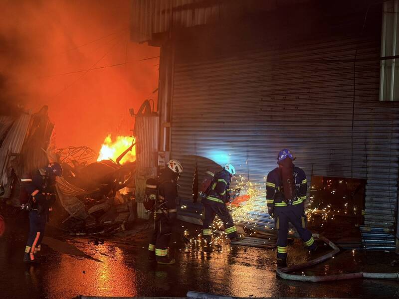 新北市八里一間木作鐵皮工廠今天凌晨失火，火勢大作，延燒燒毀三間工廠，起火原因仍待調查，新北市針對鄰近雙北四區發出空汙警戒。（記者吳仁捷翻攝）