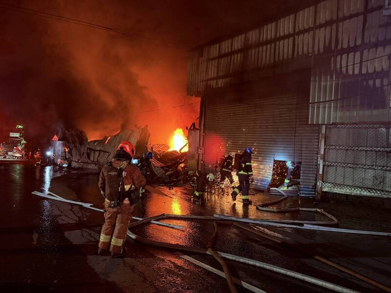 新北市八里一間木作鐵皮工廠今天凌晨失火，火勢大作，延燒燒毀三間工廠，起火原因仍待調查，新北市針對鄰近雙北四區發出空汙警戒。（記者吳仁捷翻攝）