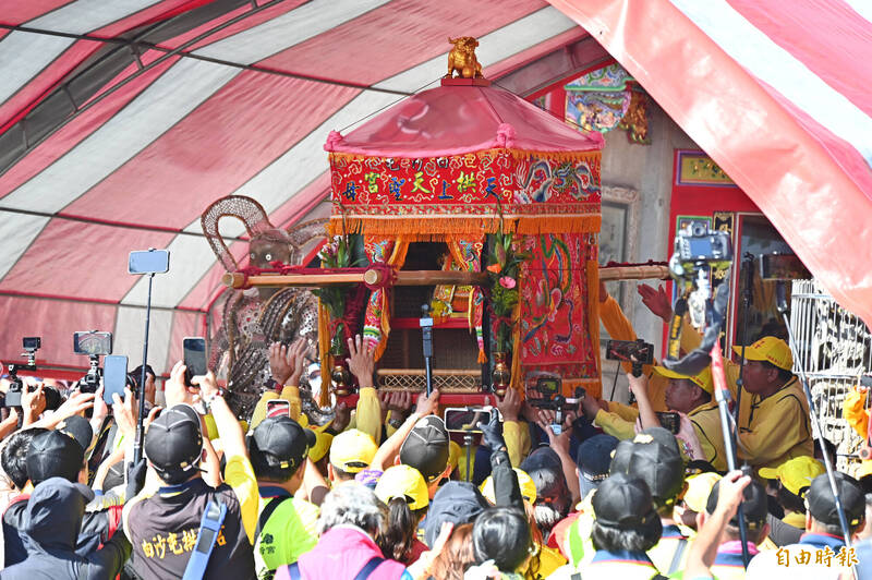 「粉紅超跑」白沙屯媽祖被抬上「鑽轎底」的檯子上。（記者李惠洲攝）