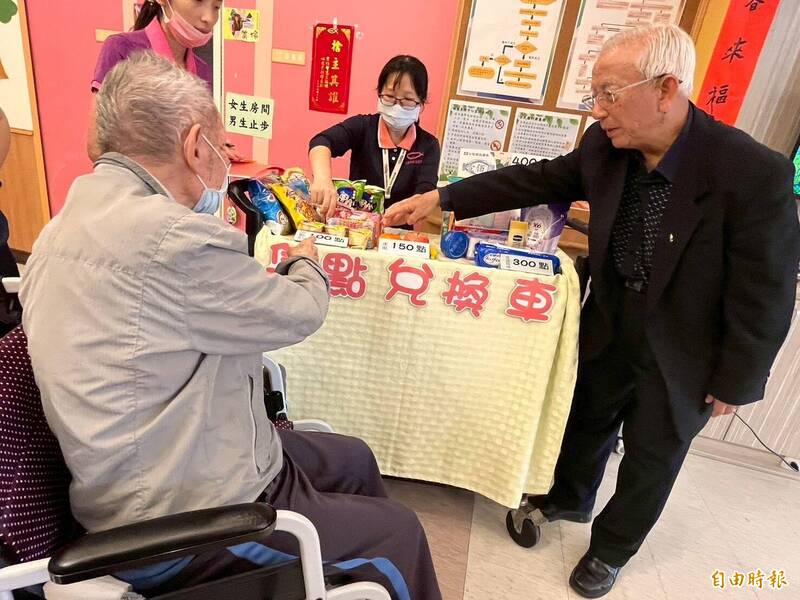 高齡八十六歲的黃德成（右二）如今仍天天上班、關心受照顧的長輩。（林澄輝社福基金會提供）