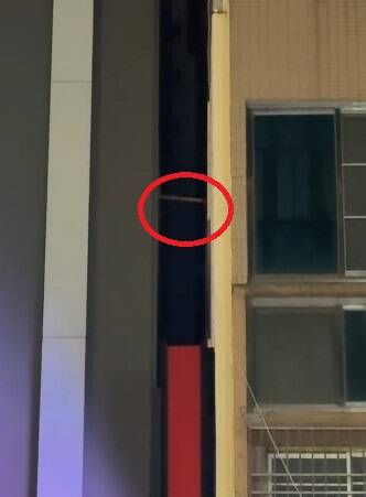 影城隔壁住戶拿竹竿狂敲影城的外牆，奇特行徑被網友拍下。（Thread網友@s.m.o.c.e提供）