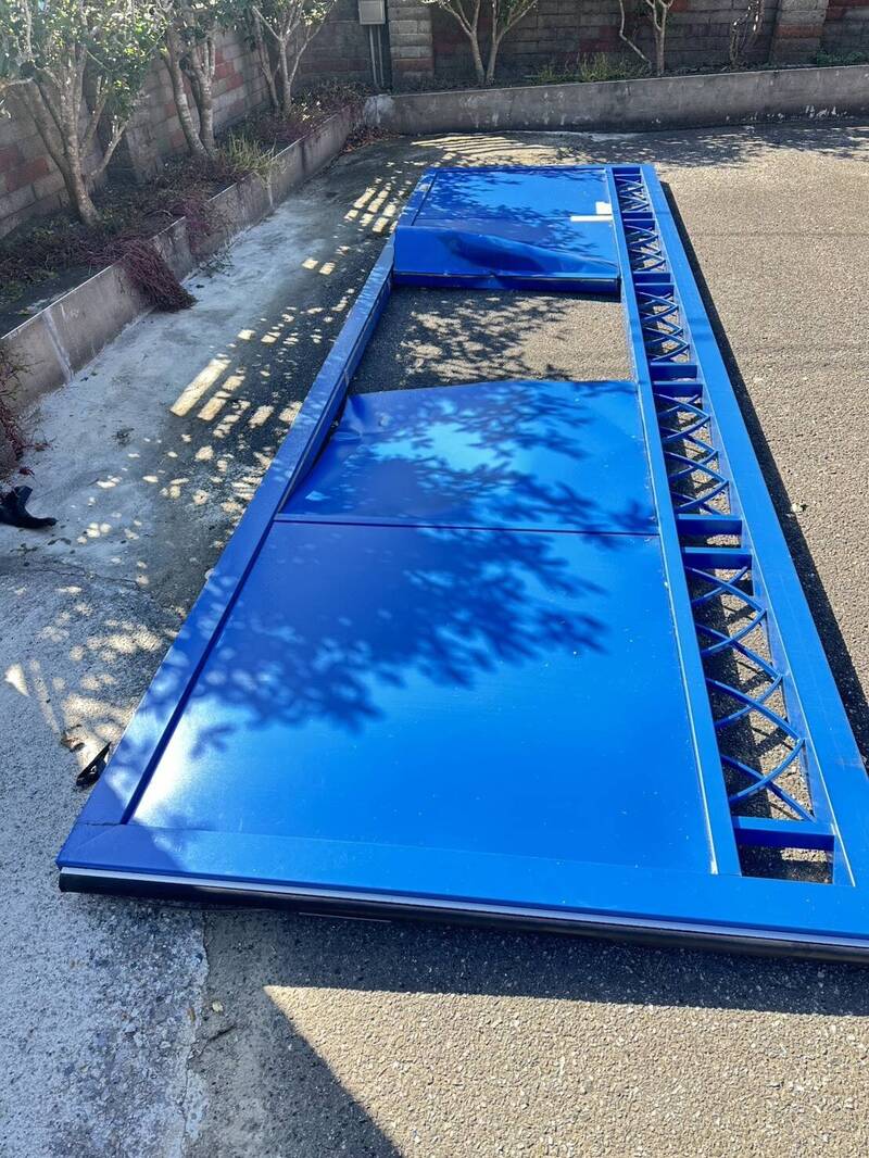 遭大型重机撞击的路旁住户铁制大门也被强大撞击力道撞倒。（记者彭健礼翻摄）