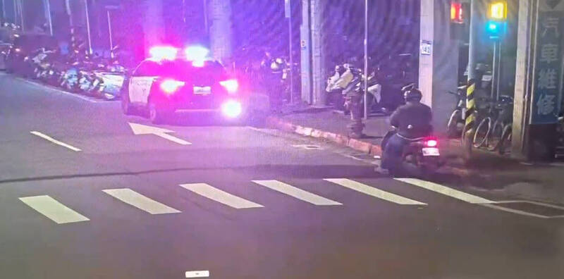 江男骑乘机车在路口右转，见到员警后竟直接停在原地，行径相当可疑。（记者郑景议翻摄）