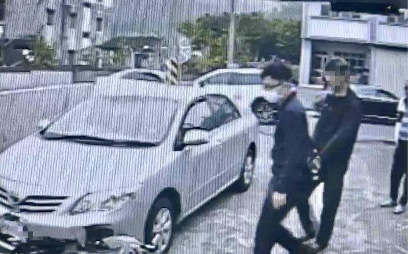 51岁黄姓男子（右后方）杀人后留在现场，警方到场准备押解上车。（民众提供）