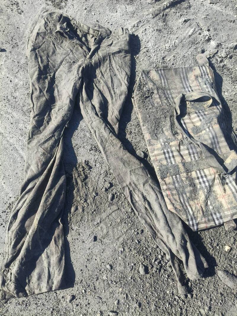 现场挖到的包包和裤子，家属认为就是父母亲穿过用过的物品。（民众提供）