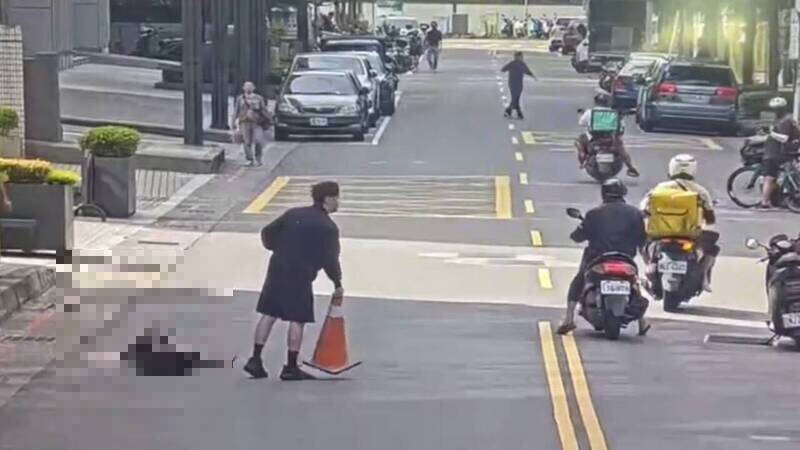 蔡女中刀倒卧血泊，见义勇为的路人拿起三角锥档放避免她遭汽机车辗过。（资料照）