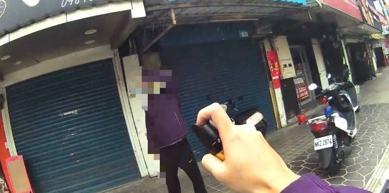 警方拿出辣椒水对邱男喷洒。（记者徐圣伦翻摄）