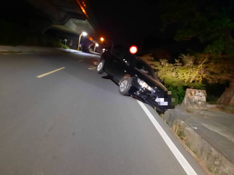 轎車失控撞向路旁卡水溝「翹孤輪」，警方到場不見駕駛。（民眾提供）