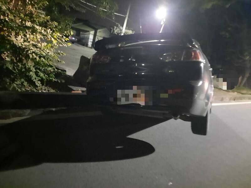 轎車失控撞向路旁卡水溝「翹孤輪」，警方到場不見駕駛。（民眾提供）