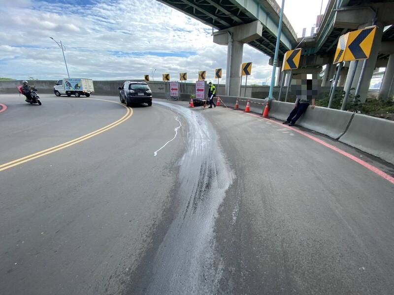 新北市五股一辆货车漏油，导致一名机车骑士摔车，警方到场维护交通。（记者吴仁捷翻摄）
