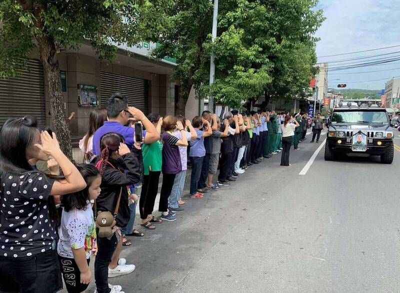 孫姓郵差出殯車隊行經其生前服務的郵局，民眾列隊敬禮高喊「下班了！」（資料照）