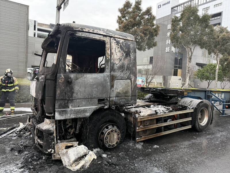 現場火勢撲滅後，警方聯繫拖車拖離已燒成廢鐵的聯結車。（記者李容萍翻攝）