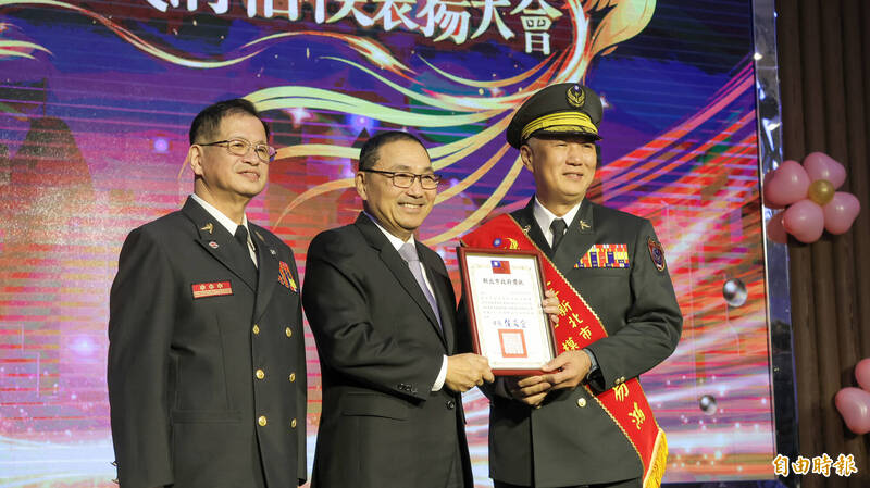 新北市消防局主秘张易鸿（右）获消防楷模。（记者黄政嘉摄）
