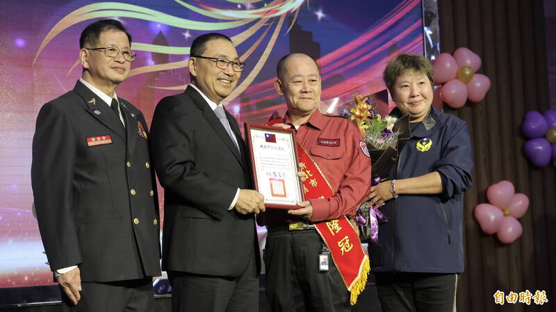 安康义消分队员倪隆冠（右２）与妻子投入义消服务长达17年，获义消楷模。（记者黄政嘉摄）