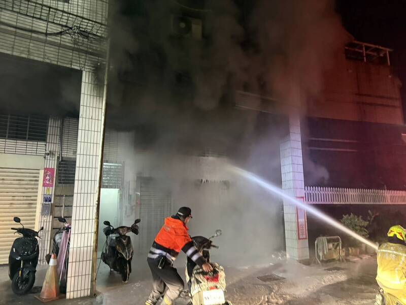 基隆市安樂區武聖街民宅1樓車庫火警，消防員灌救撲滅火勢。（記者林嘉東翻攝）