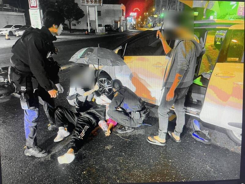 恆春昨夜發生一起驚悚事故，盧姓男子開車大迴轉，造成直行機車閃避不及自摔，眾人抬車助江姓女騎士脫困。（警方提供）