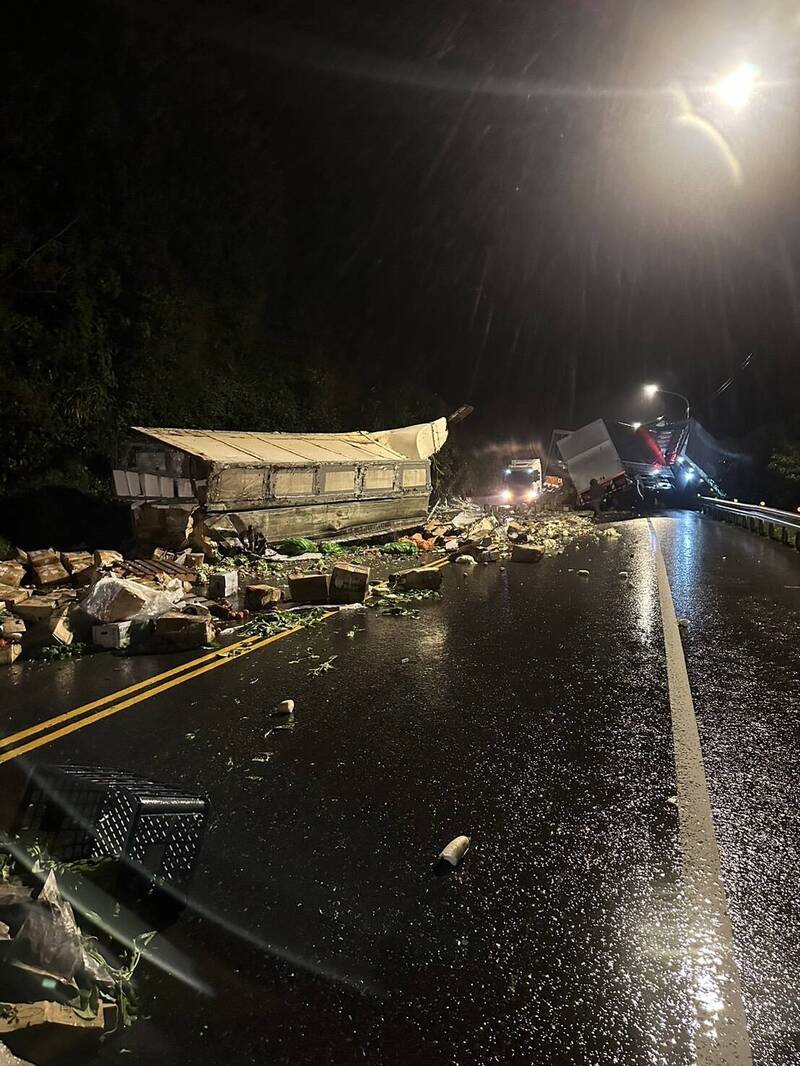 一輛滿載蔬菜的貨運曳引車，失控自撞護欄，後方子車應聲翻覆，蔬菜散落一地。（記者林嘉東翻攝）