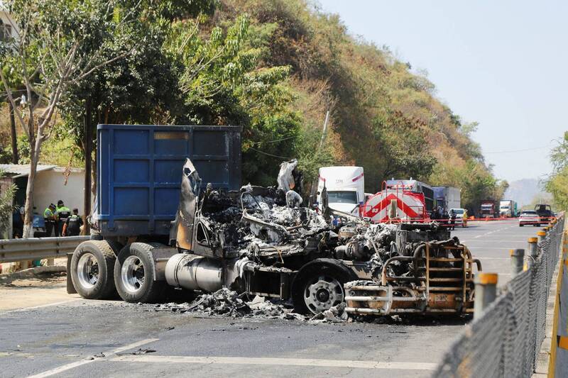 墨西哥頭號毒梟「金髮男」22日遭擊斃後，武裝集團在多個州發動路障與縱火報復。圖為阿卡普科公路上遭燒毀的大型車輛殘骸。（路透）