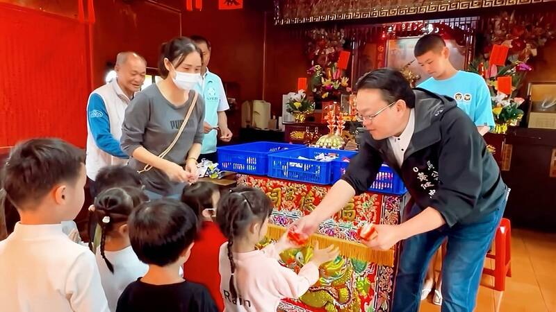 馬公市長黃健忠現場發放筊杯，讓小朋友體驗擲筊樂趣。（馬公市公所提供）