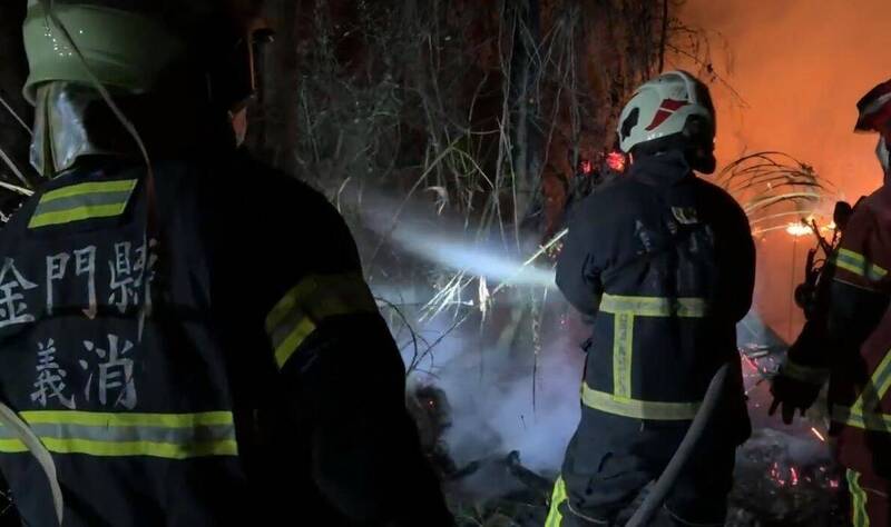 金門山后村鎮海宮附近驚傳草地火警，打火弟兄尋找地點開闢防火巷。（讀者提供）