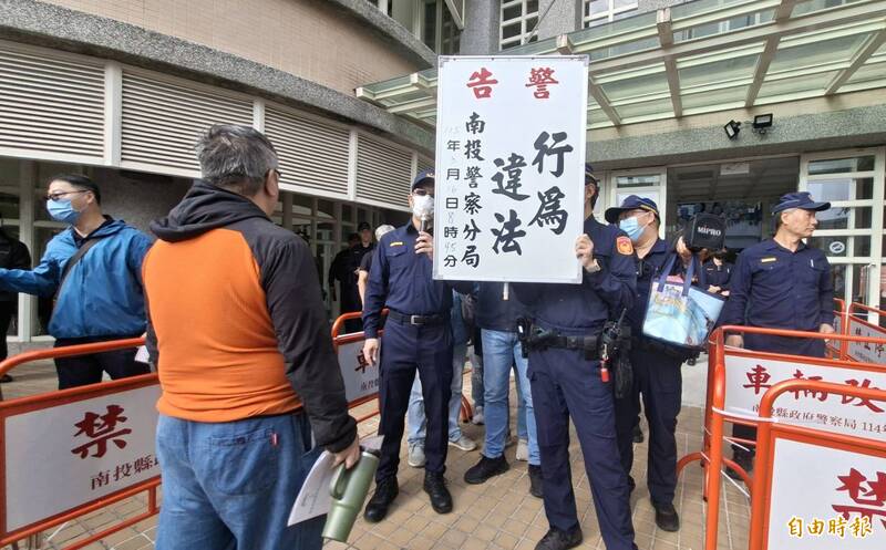 南投縣政府16日召開名間焚化爐環評範疇界定會議，警方舉牌警告場外抗議民眾違反集遊法。（記者張協昇攝）