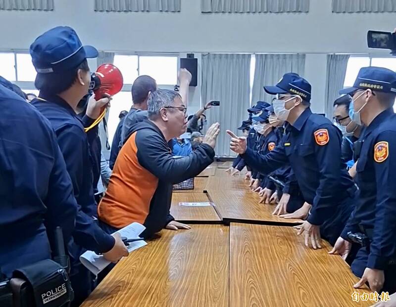 南投縣政府16日召開名間焚化爐環評範疇界定會議，民眾不滿會場以桌椅阻隔，與警方爭論。（記者張協昇攝）