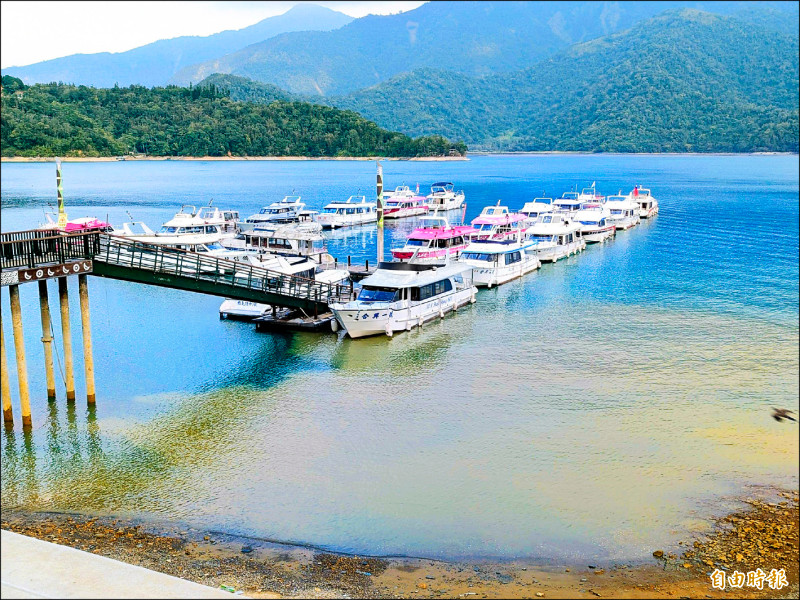 日月潭水位大降，潭區出現「陰陽海」，相較過往的湖光山色，潭區面臨枯水期也難擋美景「變色」。（記者劉濱銓攝）