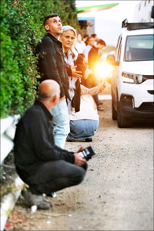 伊朗發射搭載集束彈頭的飛彈襲擊以色列，報復以軍擊斃伊朗安全首長拉里賈尼。圖為以色列民眾在飛彈來襲時就地掩蔽。（路透）