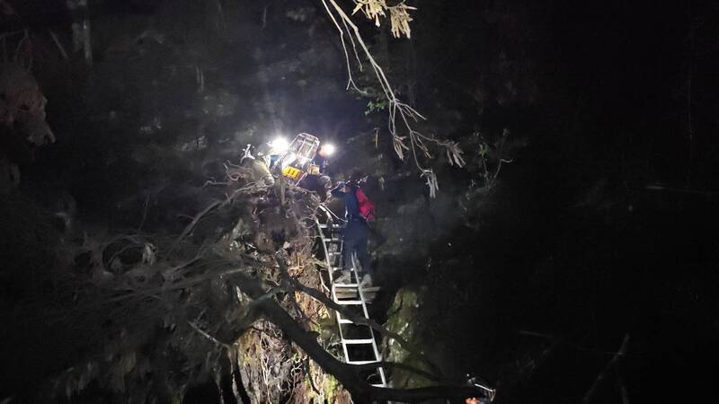 女攀西巒大山墜林道受困 消防連夜搬運救下山