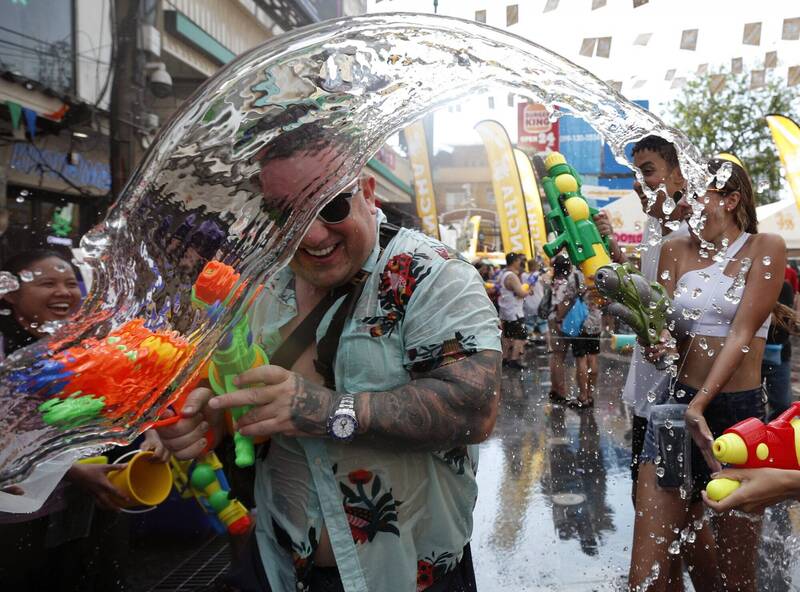 泰國潑水節出遊潮超速酒駕車禍暴增，造成不少死傷。圖為去年在泰國曼谷考山路旅遊景點，外國遊客參與水槍大戰，慶祝一年一度的潑水節。（歐新社）