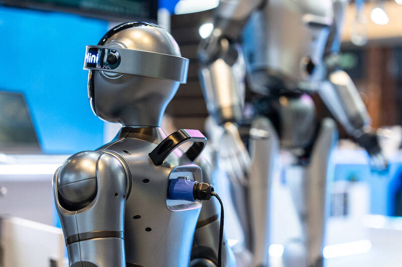 图为今（13）日在香港的展览会上，一个人形机器人正在充电待机。（美联社）