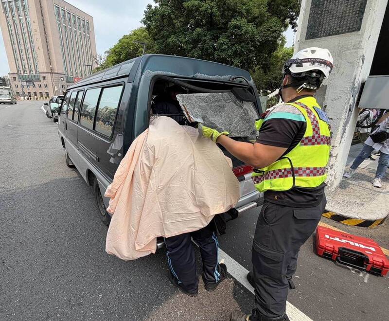 单车男撞厢型车头卡挡风玻璃被迫站著，消防员拆玻璃抢救。（消防局提供）