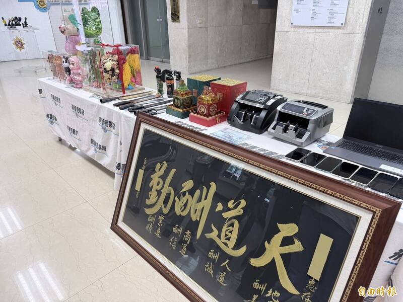警方查扣帮派狮头、堂口匾额、库柏力克熊、泡泡玛特、长刀等大批赃证物。（记者邱俊福摄）