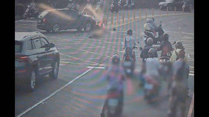 機車騎士遭休旅車撞擊後，騎士跌落一旁，卡在休旅車下方的機車瞬間起火。（圖由民眾提供）