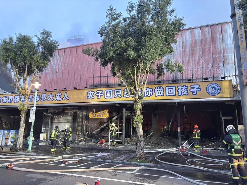 桃園平鎮夾娃娃機店凌晨突發大火全面燃燒，消防人員全力搶救。（記者李容萍翻攝）