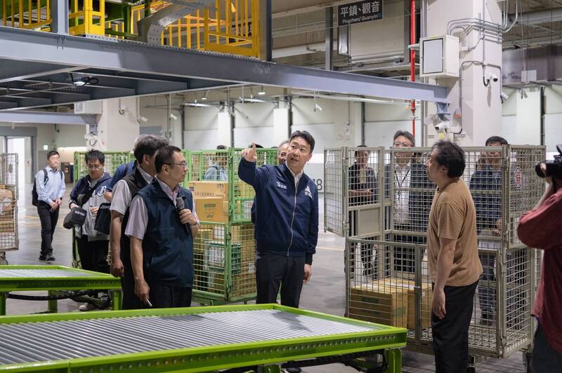 交通部長陳世凱視察包裹分揀機器設備及運作情形，並詢問第一線同仁作業現況。（交通部提供）