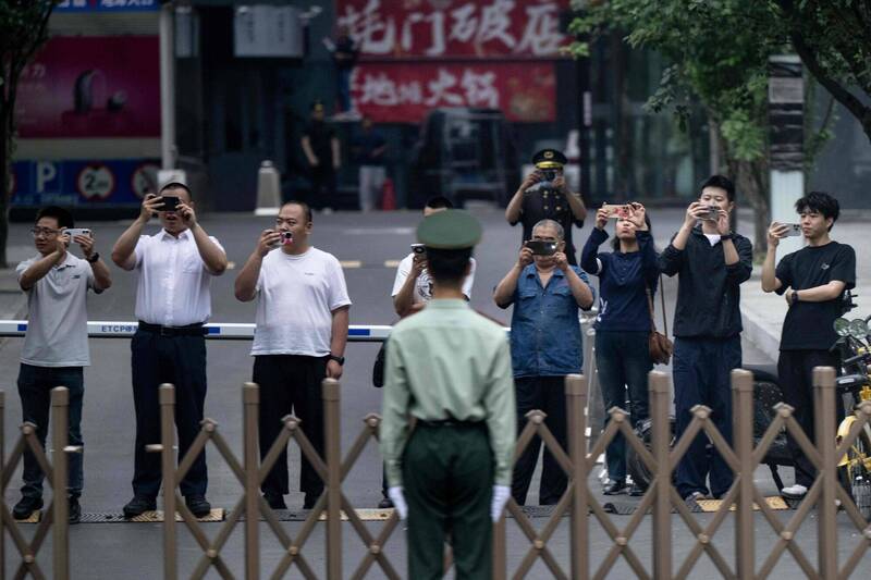 美国总统特朗普近日访华与中国国家主席习近平会谈,习特二人继昨日在北京人民大会堂会面,今日更到北京中南海会晤。 在外头也有人注视车队进入中南海。 (法新社)