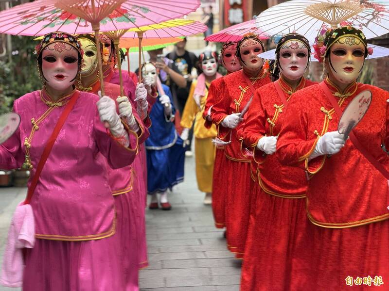 「金門迎城隍」活動隊伍中的「十二婆姐」，輕盈一致的步伐帶來的空靈氛圍，是整場焦點 之一。（記者吳正庭攝）