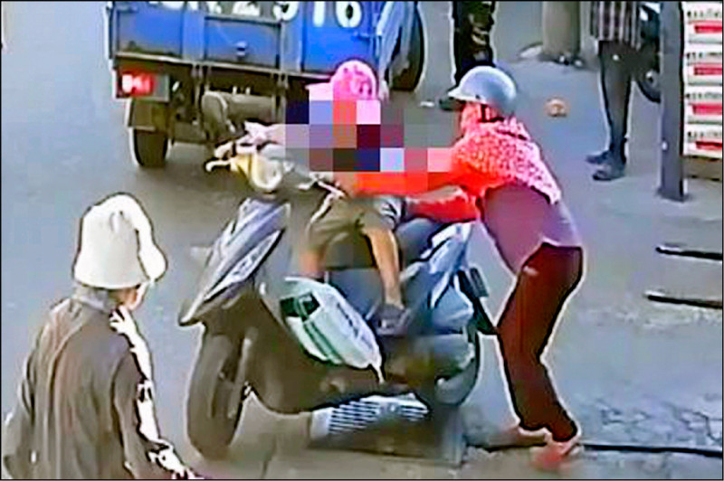 男童身高不足，爬上機車座椅時因身體失去平衡往前傾，阿嬤還上前攙扶。
（民眾提供）