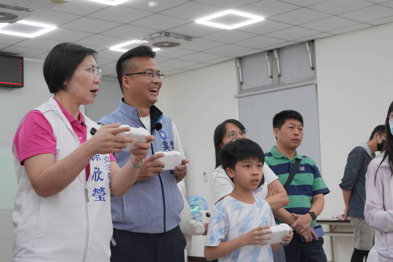 立委徐欣瑩（左起往右）、縣議員吳旭智跟著小朋友一起大玩無人機足球。（吳旭智辦公室提供）