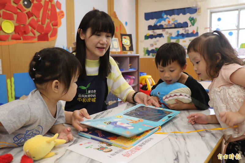 中和連城公托親子館黃品珍老師利用繪本為幼兒解說海底世界的生物 吸引小朋友觀賞。(記者翁聿煌攝)